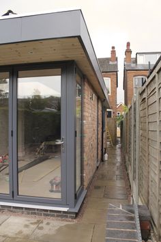 an outside view of a house with glass doors and brick buildings in the back ground