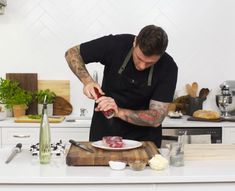 a man in black shirt preparing food on counter top