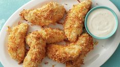 some fried food on a white plate with dipping sauce