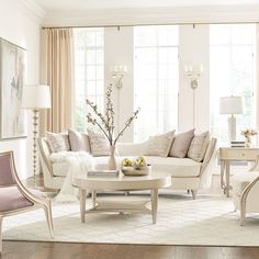 a living room filled with white furniture and lots of window sill space in front of the windows