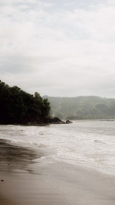 a person walking on the beach with an umbrella