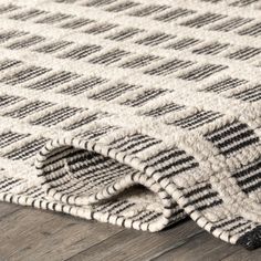 a close up view of a rug on the floor with wood floors in the background