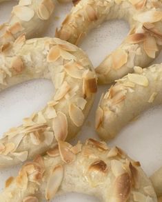 several pretzels with almonds on them sitting on a white surface