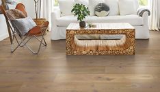 a living room with white furniture and wood flooring on the floors, including a coffee table