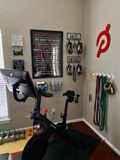 there is a stationary bike in the corner of this room with many sports memorabilia on the wall