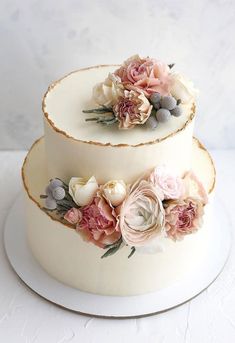 two tiered wedding cake with flowers on top