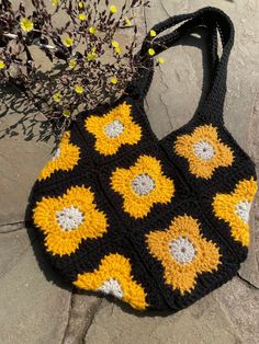 Retro inspired Granny Square Tote Bag with golden yellow flowers in a black background.  This small tote bag is perfect for a trip to the farmer's market or to hold on to your belongings for daily use! The best part - it's machine washable! As needed, throw it in the wash on a gentle cycle and then lay flat to dry. Handmade Black Bags For Spring, Spring Black Crochet Bag For Everyday Use, Black Crochet Bag For Everyday Spring Use, Everyday Sunflower Design Tote Bag, Everyday Sunflower Tote Bag, Rectangular Everyday Bag With Sunflower Print, Everyday Rectangular Bag With Sunflower Print, Rectangular Bag With Sunflower Print For Everyday Use, Rectangular Sunflower Print Bag For Everyday