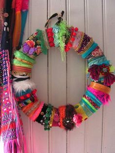 a colorful wreath is hanging on the front door with other items around it, including bracelets and hair clips