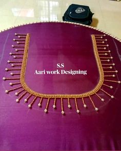 an elaborate necklace is displayed on a purple tablecloth with the words aari work designing