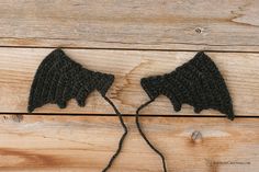 two black crocheted objects on wooden planks