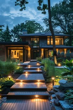 a long wooden path with lights on it leading to a large house in the woods