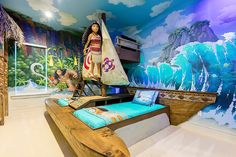 a room with a bed, desk and wall mural