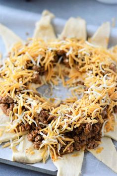 an appetizer made with tortilla shells, cheese and ground beef is ready to be eaten