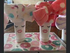 three pink and white stuffed animals in vases