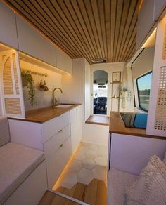 an interior view of a tiny home with wood flooring and white walls, along with built - in seating