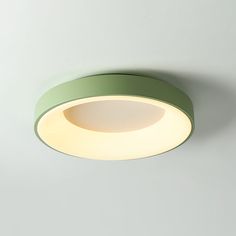 a green circular light fixture on a white wall