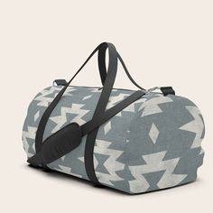 a duffel bag with an arrow pattern on the front and side, sitting upright