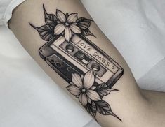 a woman's arm with an old school cassette tattoo on it