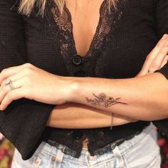 a woman's arm with a flower tattoo on it