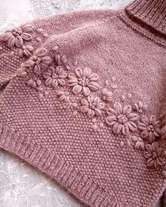 a pink sweater with flowers on it