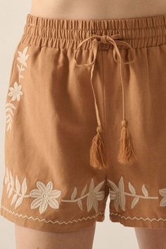 Linen-blend shorts. Floral embroidery. Elastic waist with tassel drawstring. Side pockets. Wide leg. Thigh length. Relaxed fit. 70% Rayon, 30% Linen. Imported. Designed in LA. Model wears size S. Floral Embroidery Cotton Shorts, Casual Mid-rise Embroidered Shorts, Casual Mid-rise Shorts With Floral Embroidery, Floral Embroidered Medium Wash Shorts, Linen High-waisted Shorts For Loungewear, Floral Embroidery, Linen Blend, Elastic Waist, Wide Leg