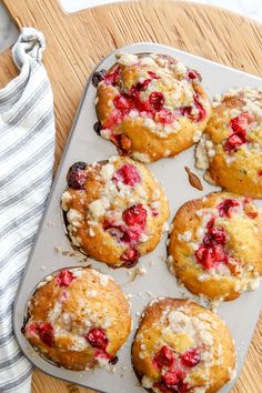 muffins with crumbled toppings sitting on a baking tray next to a towel