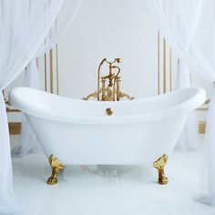 an old fashioned bathtub in a white bathroom with gold fixtures