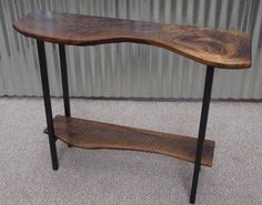 a wooden table sitting on top of a carpeted floor next to a metal wall