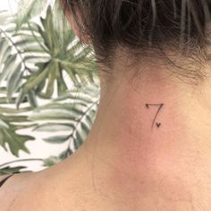 a woman's neck with a small tattoo on it