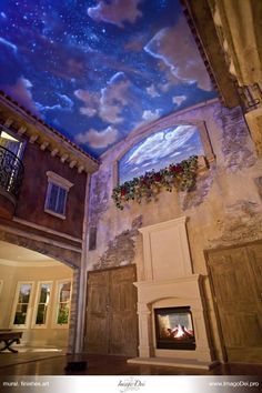 the ceiling is decorated with stars and clouds above a fire place in an old building