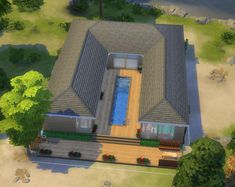 an aerial view of a house with a pool in the middle and trees around it