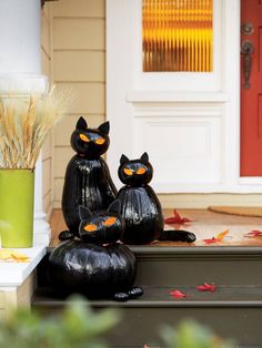 two black cats sitting on top of a step