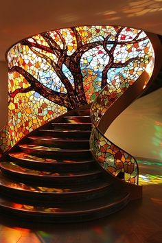 a spiral staircase with a stained glass tree on it