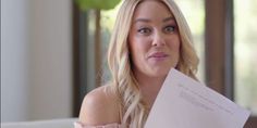 a woman sitting on a couch holding a piece of paper