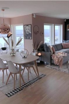 a living room filled with furniture and a large window next to a dining room table