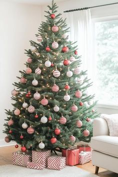 a decorated christmas tree in a living room with red and white ornaments on the top