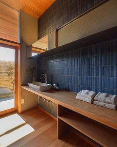 a bathroom with wooden floors and blue tiles on the wall, along with two sinks