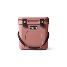 a pink yeti cooler with black handles and straps on the handle, sitting against a white background