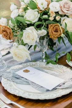 an elegant table setting with white and brown flowers