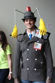 a man in a costume made to look like a doctor who is holding two yellow gloves