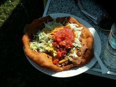 a pizza sitting on top of a white plate covered in toppings next to a water bottle