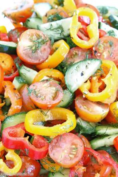 a salad with tomatoes, cucumbers, and other veggies on it