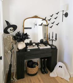 a black table topped with a mirror and lots of halloween decorations on top of it