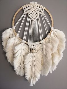 a white dream catcher hanging on the wall