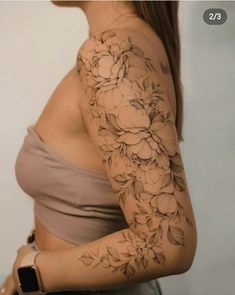 a woman's arm with flowers on it, and the top half of her sleeve is