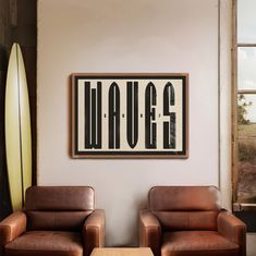 two brown leather chairs sitting next to each other in front of a surfboard on the wall