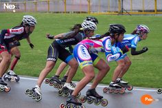 several people riding roller skates on a road in front of grass and yellow barriers