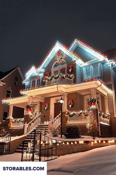 a house with christmas lights on it and stairs leading up to the front door is lit up