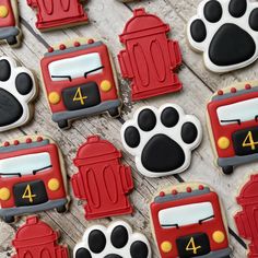 decorated cookies with firetrucks and paw prints on wooden table next to each other