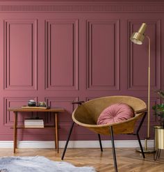 a living room with pink walls and wooden furniture in front of the wall is a brown chair